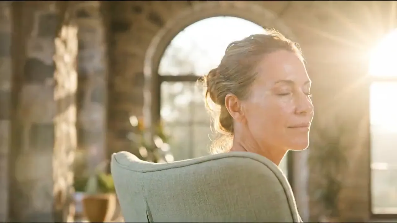 Illustrative film moving from a patient in warm daylight into a golden ribbon of light and on to a settled synovial joint lining with immune cells drifting away from it